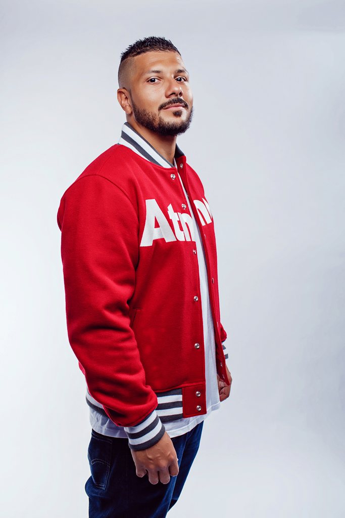 Full-length portrait of #ItsJuniorJ in a red varsity jacket